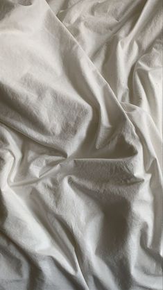 an unmade bed with white sheets on it