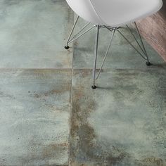 a white chair sitting on top of a wooden floor next to a table and chairs