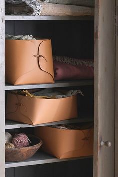 an open closet with baskets and yarn on the shelves, next to a pair of scissors