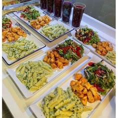 several plates with different types of food on them sitting on a table next to drinks