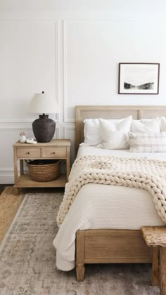 a bedroom with white walls and wooden furniture