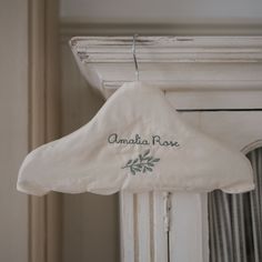 a white coat hanger with the name amatia rose hanging from it's side