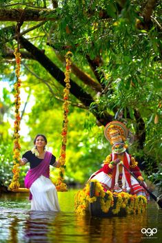 a woman standing in the water next to a man on a swing with flowers hanging from it