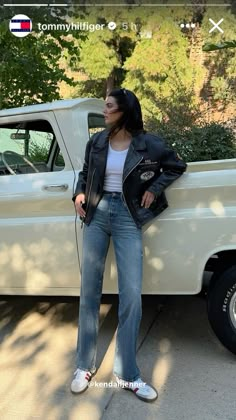 a woman standing next to a white truck