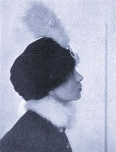 an old black and white photo of a woman wearing a hat with feathers on it