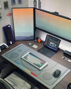 a computer desk with two monitors and a laptop on it, along with other office supplies