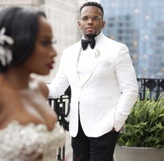 a man in a tuxedo standing next to a woman