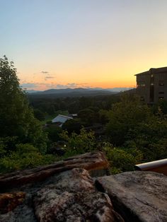 the sun is setting over some trees and buildings