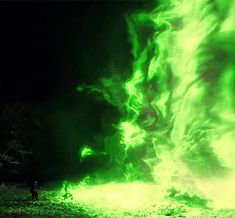 a person standing in front of a large green fire