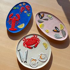 three different colored plates sitting on top of a wooden table