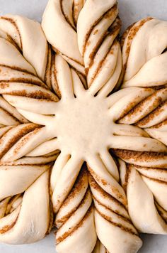 a white plate topped with lots of cinnamon buns covered in icing next to each other