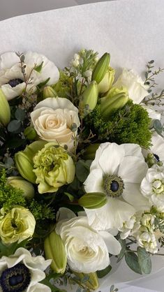 a bouquet of white and green flowers on a table