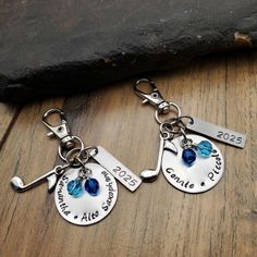 two personalized key chains with charms attached to them