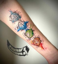 an arm with watercolor tattoos on it, including three different shapes and colors that appear to be painted