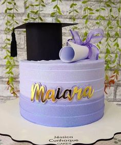 a purple cake with a graduation cap and diploma on top that says maalara