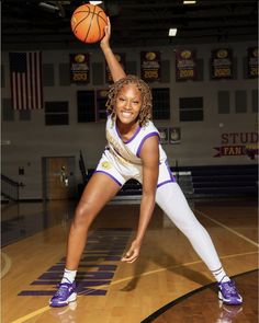 a young woman holding a basketball in her right hand