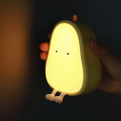 a person is holding a small light in their hand and it looks like an egg