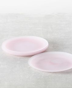 two pink plates sitting next to each other on a table