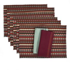 four placemats with red and brown plaid designs on them, each folded in different patterns