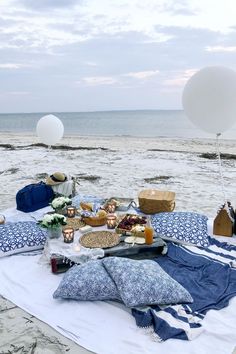 a picnic on the beach with balloons and food