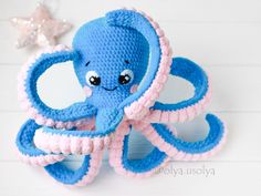 an octopus stuffed animal sitting on top of a white table next to a starfish