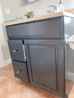 a bathroom with a sink, mirror and toilet paper dispenser in it