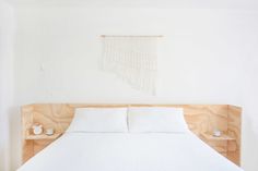 a bed with white sheets and wooden head board