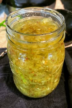 a glass jar filled with yellow liquid sitting on top of a table