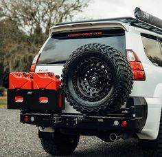 the back end of a white truck with an atv on it's flat tire