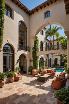 an outdoor living area with couches, tables and potted plants