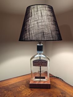 a lamp that is sitting on top of a wooden table next to a glass bottle