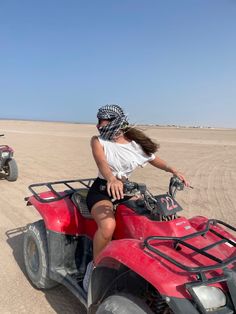 two people riding four wheelers in the desert