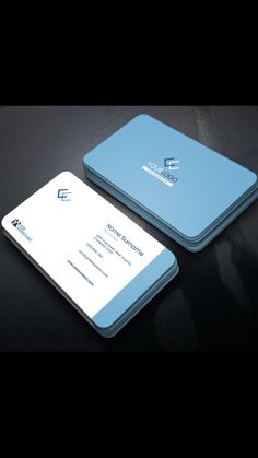 two business cards sitting next to each other on top of a black table with a white and blue logo