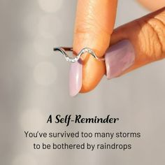 a woman's hand with a ring on her finger that reads, a self - reminder you've survived too many storms to be bothered by raindrops