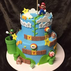 a blue cake decorated with mario and his friends