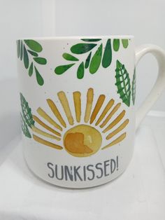 a coffee cup with the words sunkied painted on it's front and side