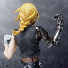 the action figure is posed in front of a gray background and holds out her hand