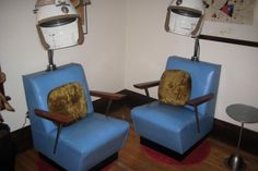 two blue chairs sitting next to each other in a room