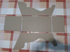 cut out pieces of cardboard sitting on top of a checkered table cloth