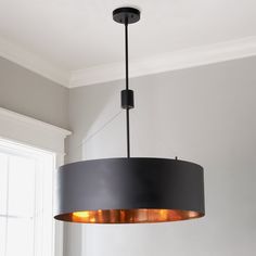 a black lamp hanging from the ceiling in a room