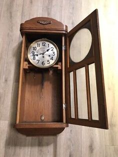 an open wooden box with a clock inside