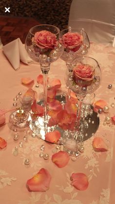 the table is set with rose petals and wine glasses