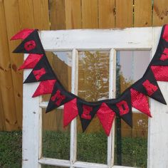 a red and black banner hanging from the side of a window