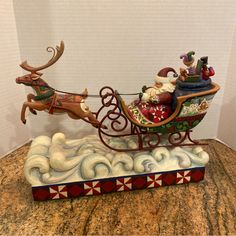 a christmas sleigh with santa claus riding in it on top of a table