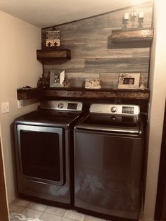 a washer and dryer in a small room with wood planks on the wall