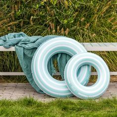 two inflatable swimming rings sitting on a park bench next to some green grass