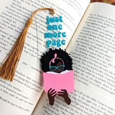 a bookmark that says just be more page on top of an open book with a tassel hanging from it