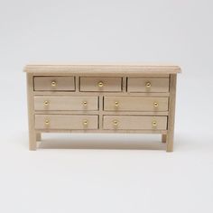 a wooden dresser with six drawers and gold knobs