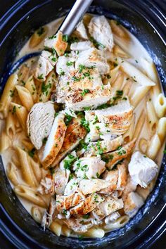 a bowl filled with pasta and chicken on top of a table