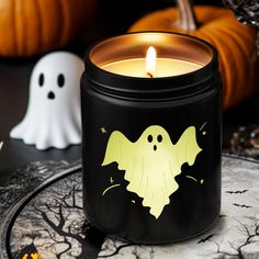 a lit candle with a ghost on it